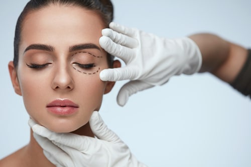 Portrait Of Beautiful Woman With Closed Eyes And Black Surgical Lines On Skin.