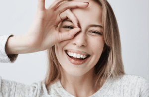 retrato de una hermosa y alegre mujer rubia sonriendo con los dedos en buen gesto.