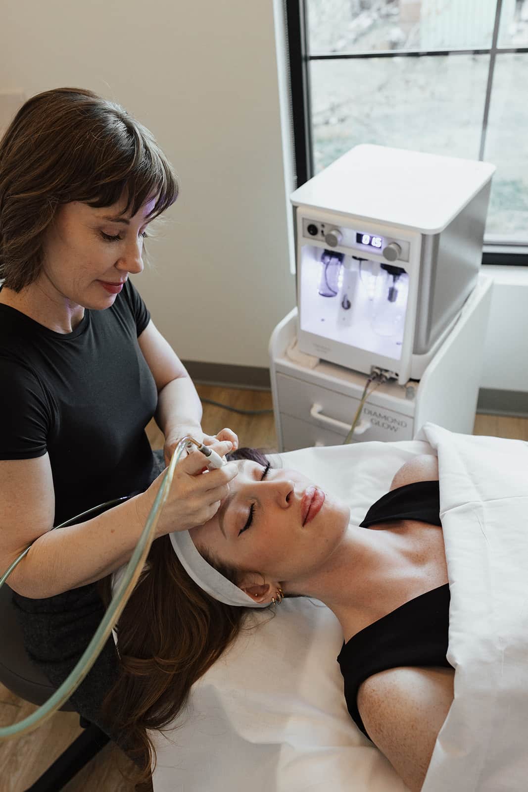 Utah Facial Plastics patient receiving a DiamondGlow facial treatment from a skincare professional.
